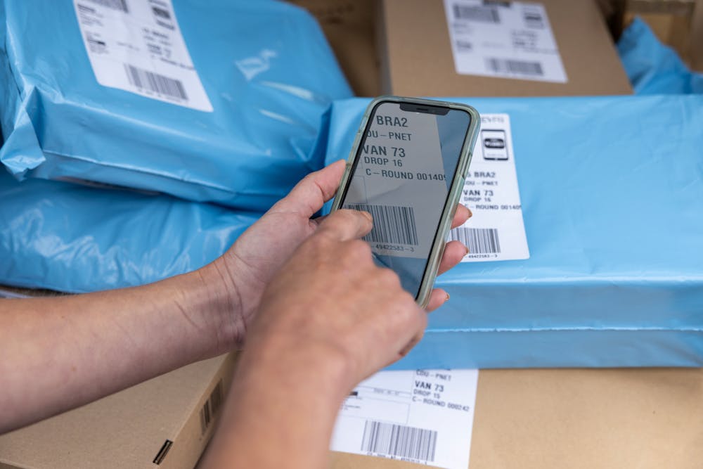 A courier scanning a parcel barcode using their mobile device