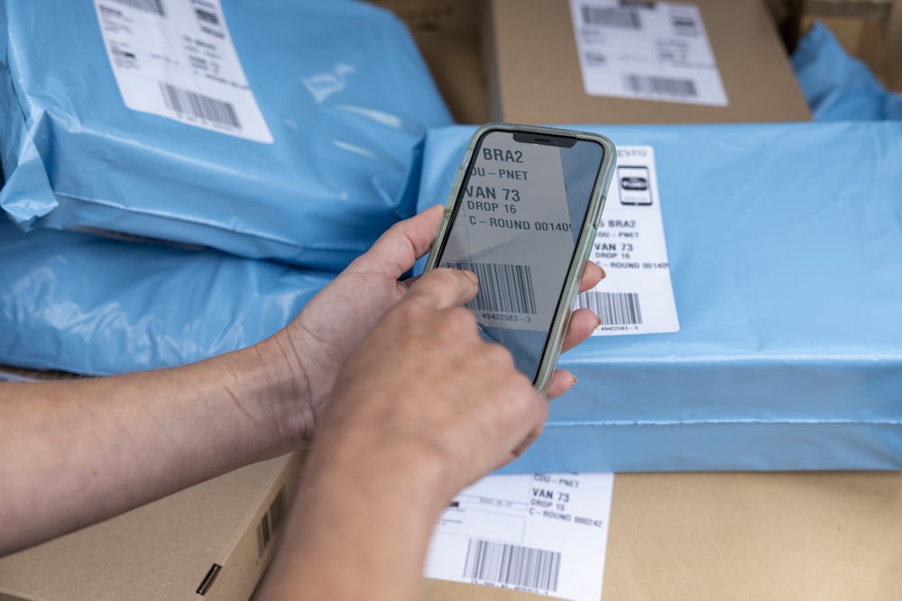 A courier scanning a parcel barcode using their mobile device