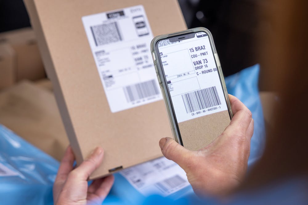 A courier scanning a parcel barcode using their mobile device