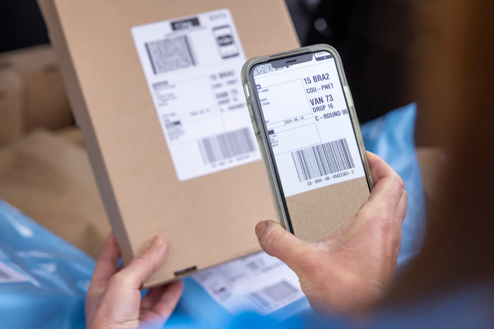 A courier scanning a parcel barcode using their mobile device