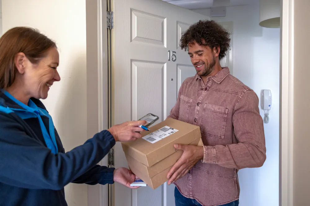 An Evri Courier scanning multiple parcels for a doorstep collection in a block of flats.