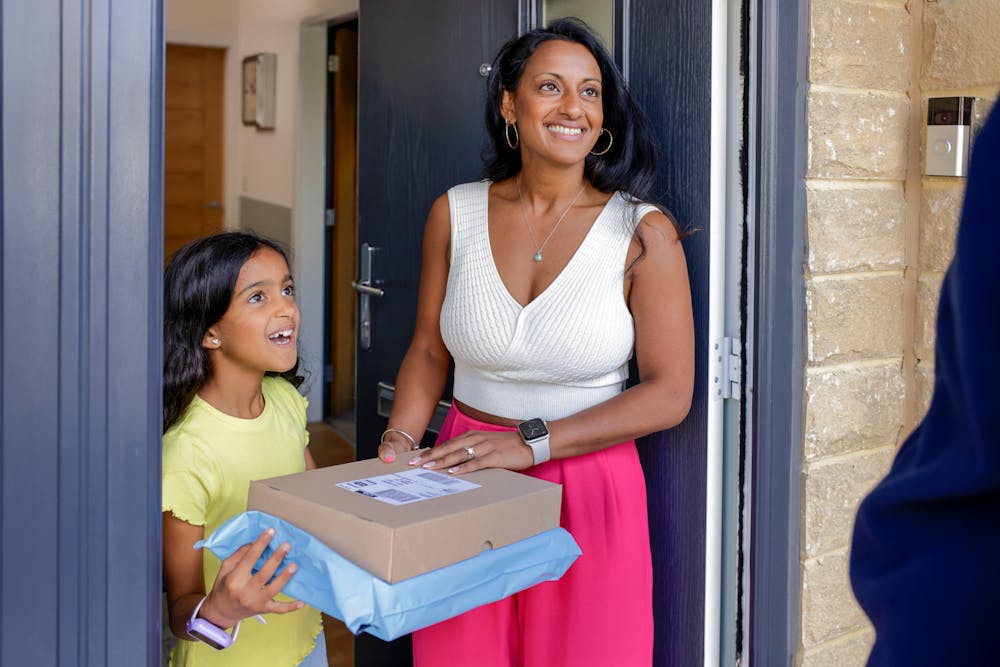 A mother and child thanking their Evri Courier after a satisfactory delivery of two parcels