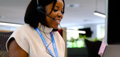 An Evri office worker is talking on a headset whilst at their laptop