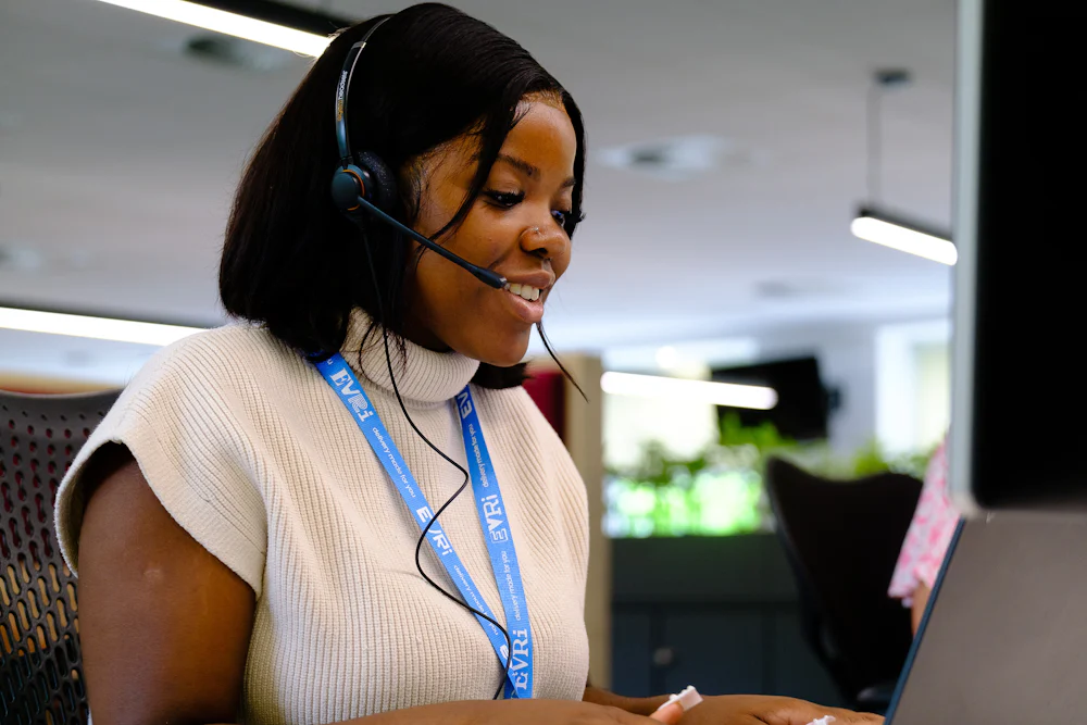 An Evri office worker is talking on a headset whilst at their laptop