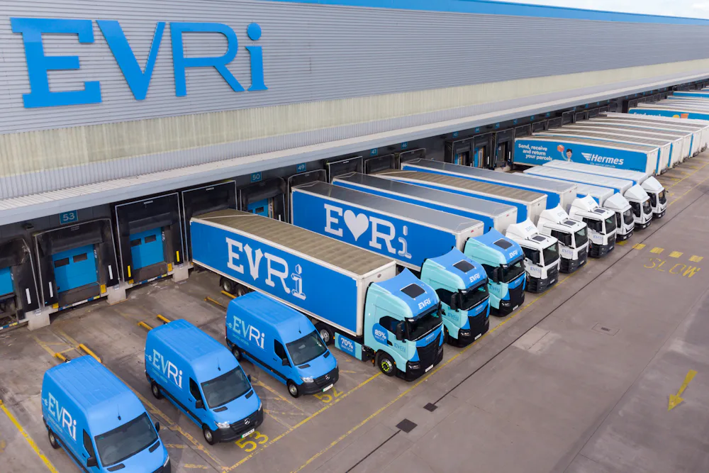 A drone shot of an Evri hub. There are rows of Evri trucks and vans of various sizes stationed at the units across the hub ready to take on parcels.