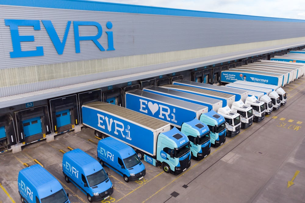 A drone shot of an Evri hub. There are rows of Evri trucks and vans of various sizes stationed at the units across the hub ready to take on parcels.
