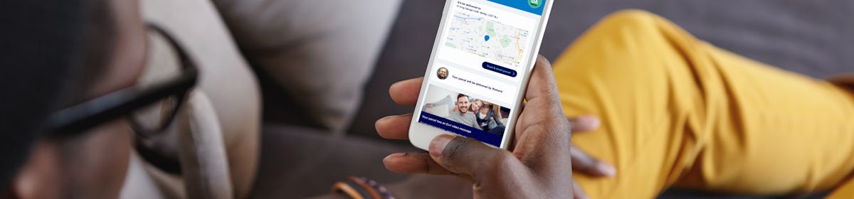 Customer looking down at their mobile with the display showing their tracking notification in full view