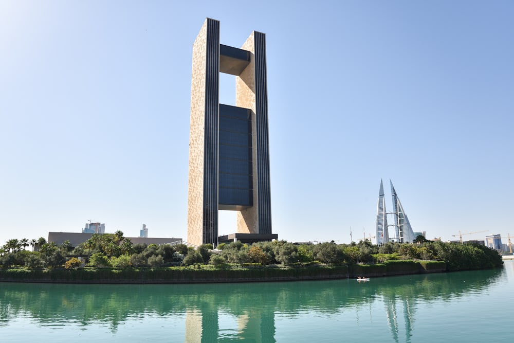 The iconic Four Seasons Hotel is pictured by the water, towering above the skyline and surrounded by greenery and blue skies