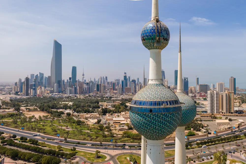A skyline view of Kuwait City can be seen with the famous Liberation Tower in the foreground.