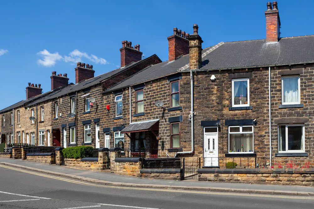 A row of terraced houses made from old cobbled stone brickwork.