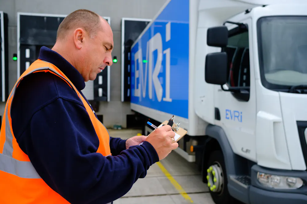 Evri driver in hi-visibility jacket doing mandatory safety checks