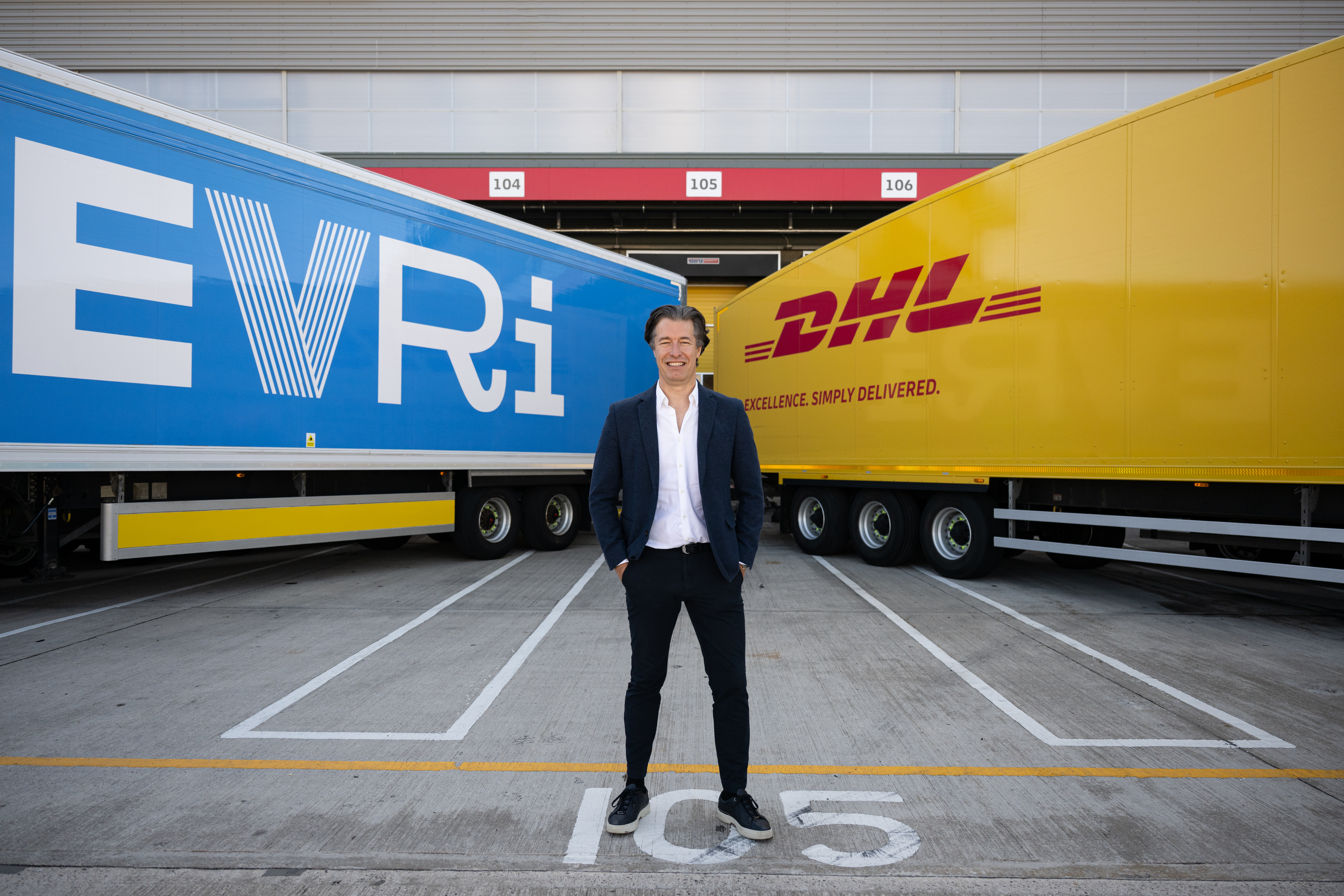 Martijn De Lange, Chief Executive Officer, Evri, between two trailers.