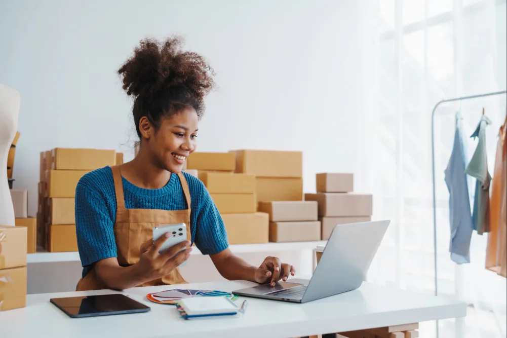 A small business owner using laptop to send parcels