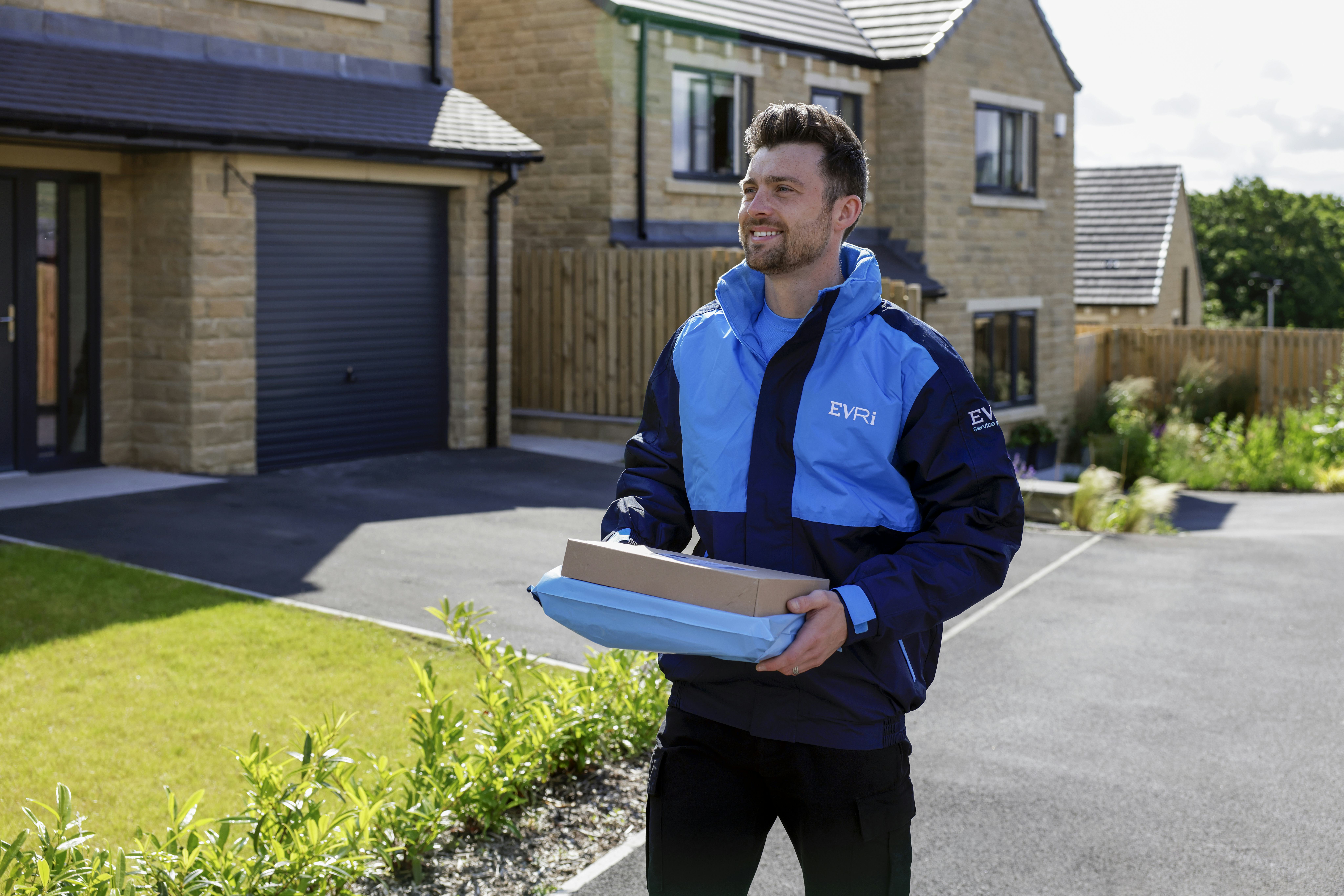 Image of Evri courier outside carrying parcels for delivery