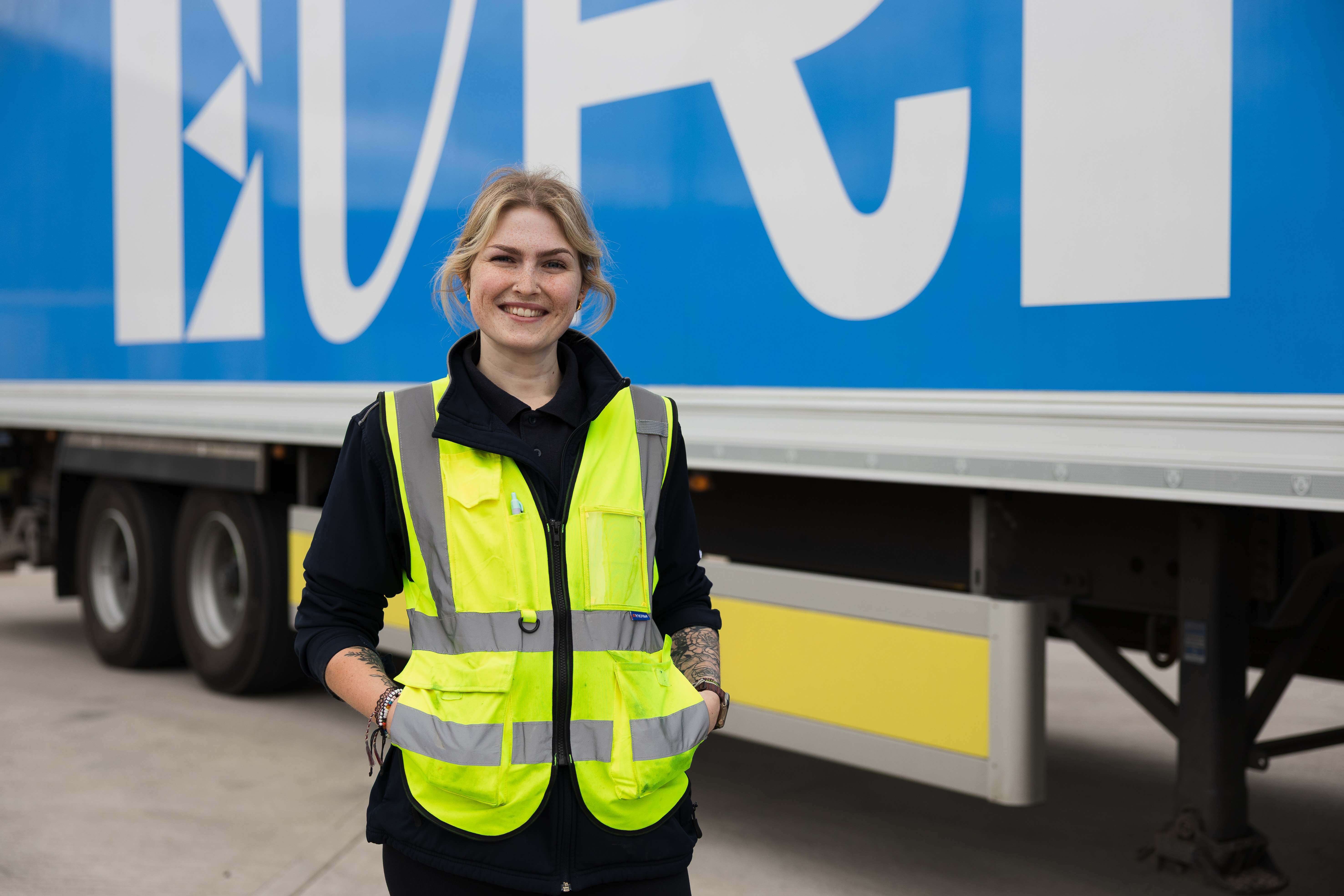 A female HGV driver poses in front of an Evri branded HGV.