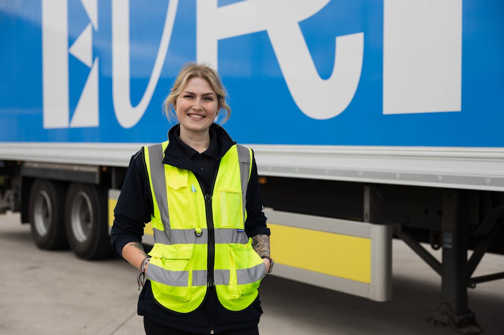 A female HGV driver poses in front of an Evri branded HGV.