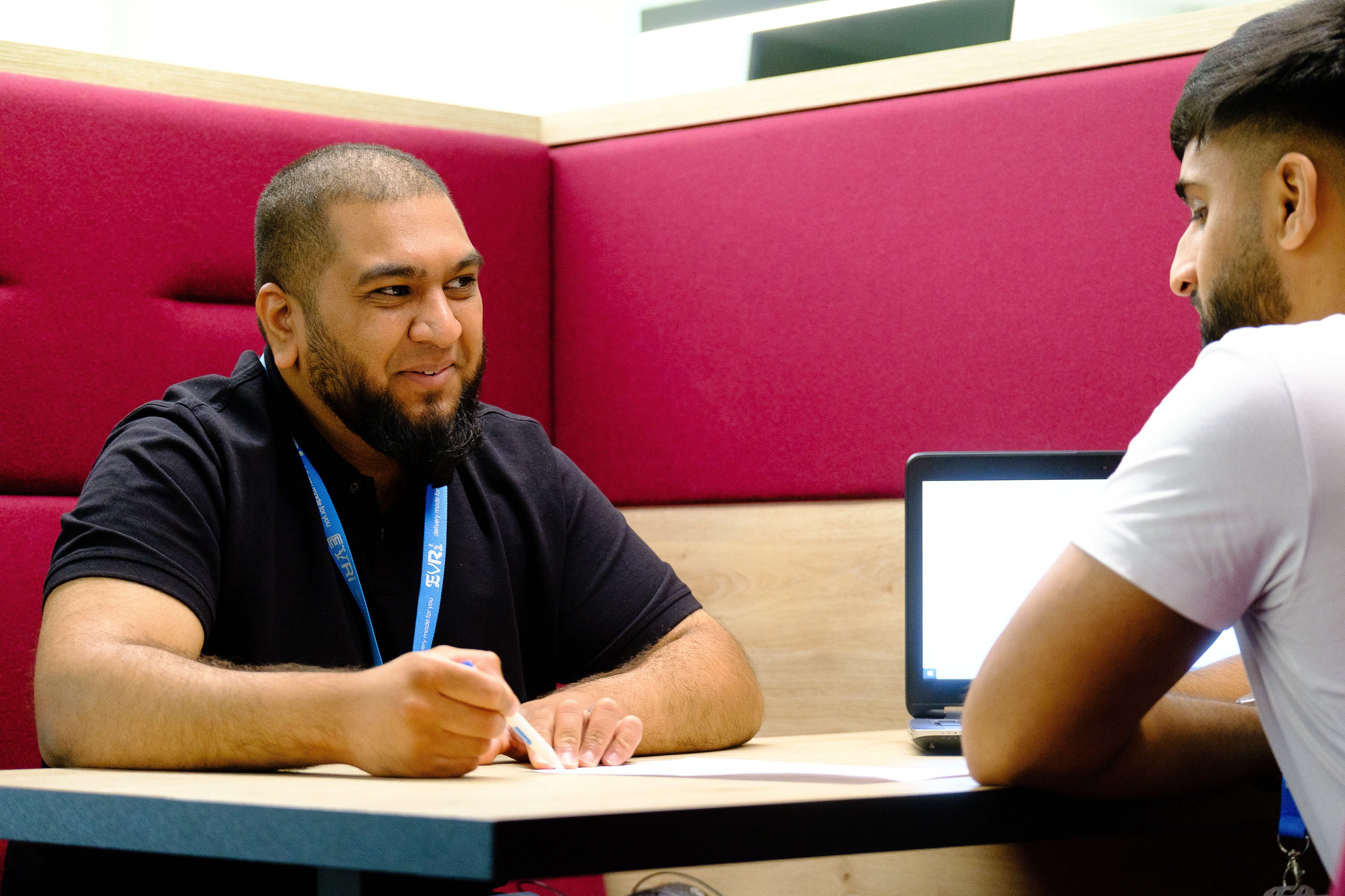 Two Evri colleagues work together at a table 