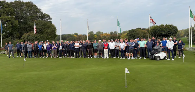 A photo of a large group of people on a golf course