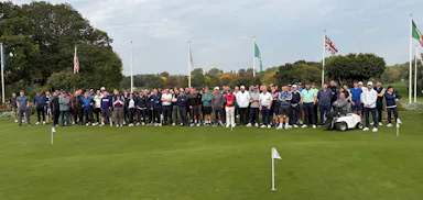 A photo of a large group of people on a golf course