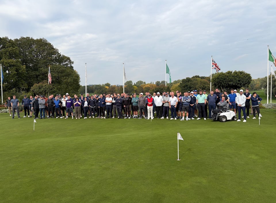 A photo of a large group of people on a golf course