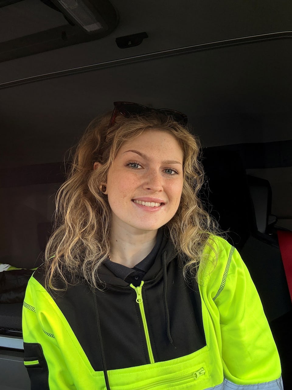 Ellie, HGV driver, smiling in her truck