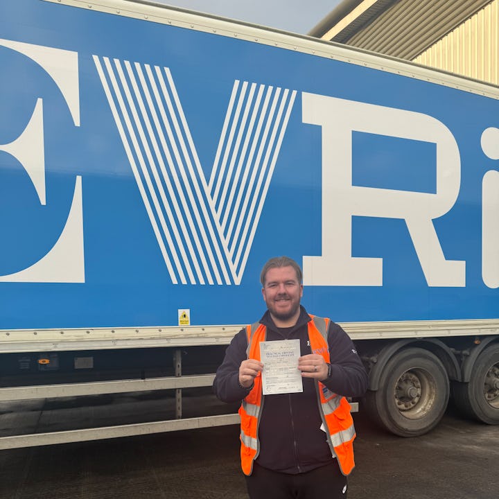 Matthew, HGV driver, smiling in front of an Evri truck