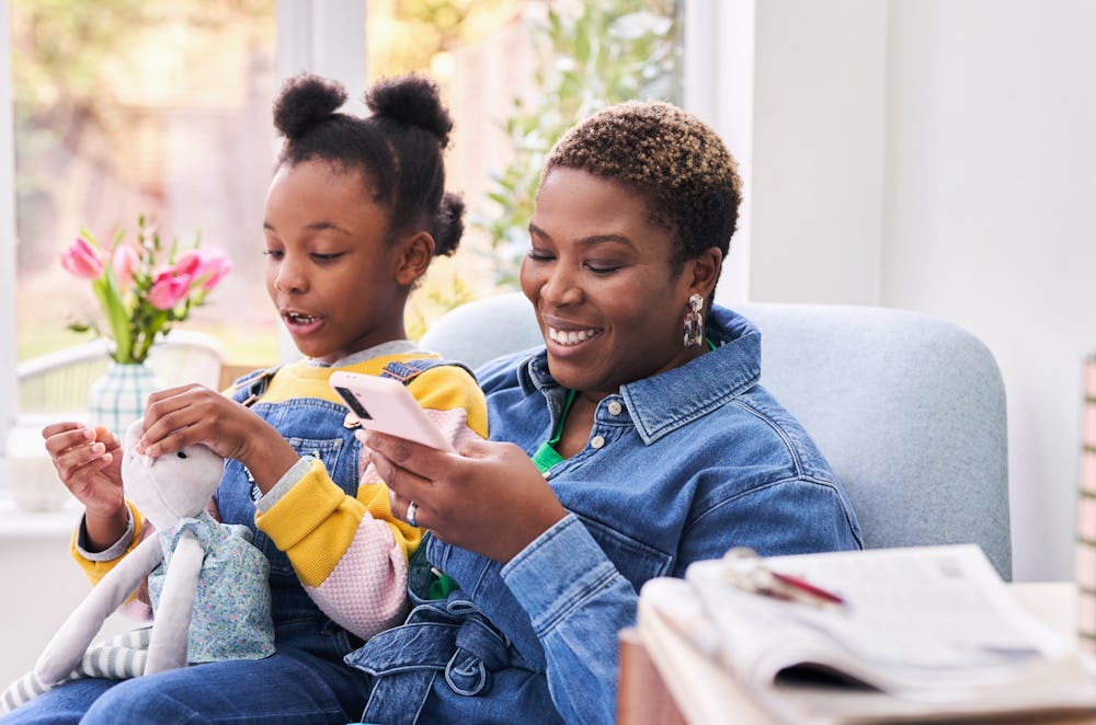 woman sat on sofa with child on lap using a smartphone