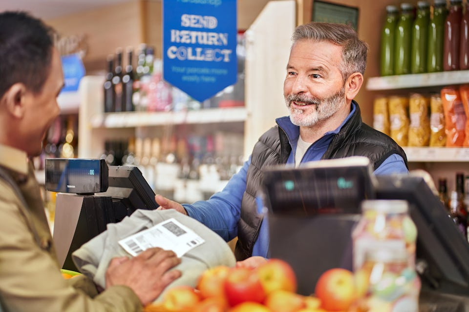 cashier taking parcel from customer over council