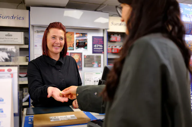 Woman paying cashier at Post Office
