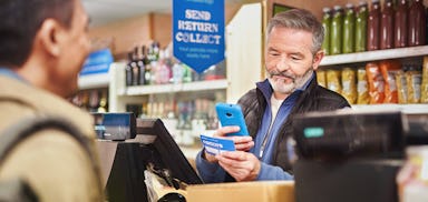 cashier scanning customers parcel on shop counter