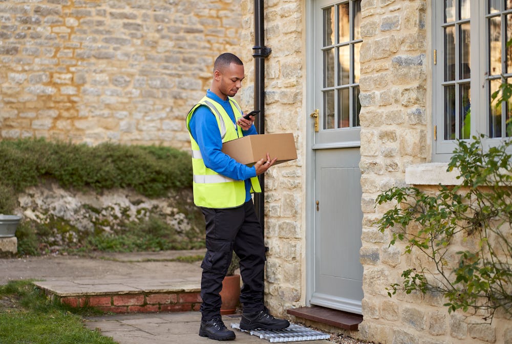 Photo of a courier delivering a parcel to a house