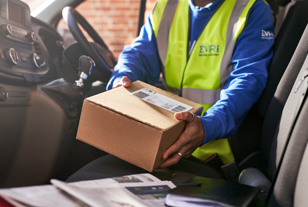 courier in van placing parcel on seat