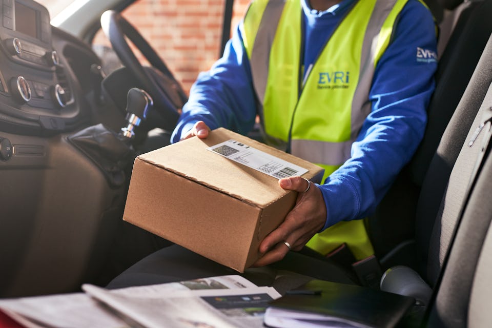 courier in van placing parcel on seat