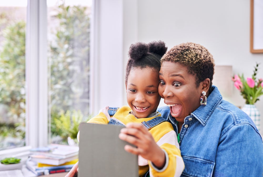 woman and child smiling at tablet device
