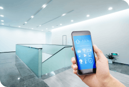 Hand holding a smartphone with an integrated security app in a clean modern building 