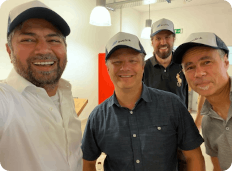 Foto von Anis Mungapen, Peter Monte, Lukas Kaiser und Markus Herren von Sitasys AG, die lächelnd ein Selfie mit evalink-Basecap machen 