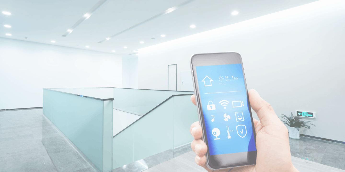 Hand holding a smartphone with an integrated security app in a clean modern building 