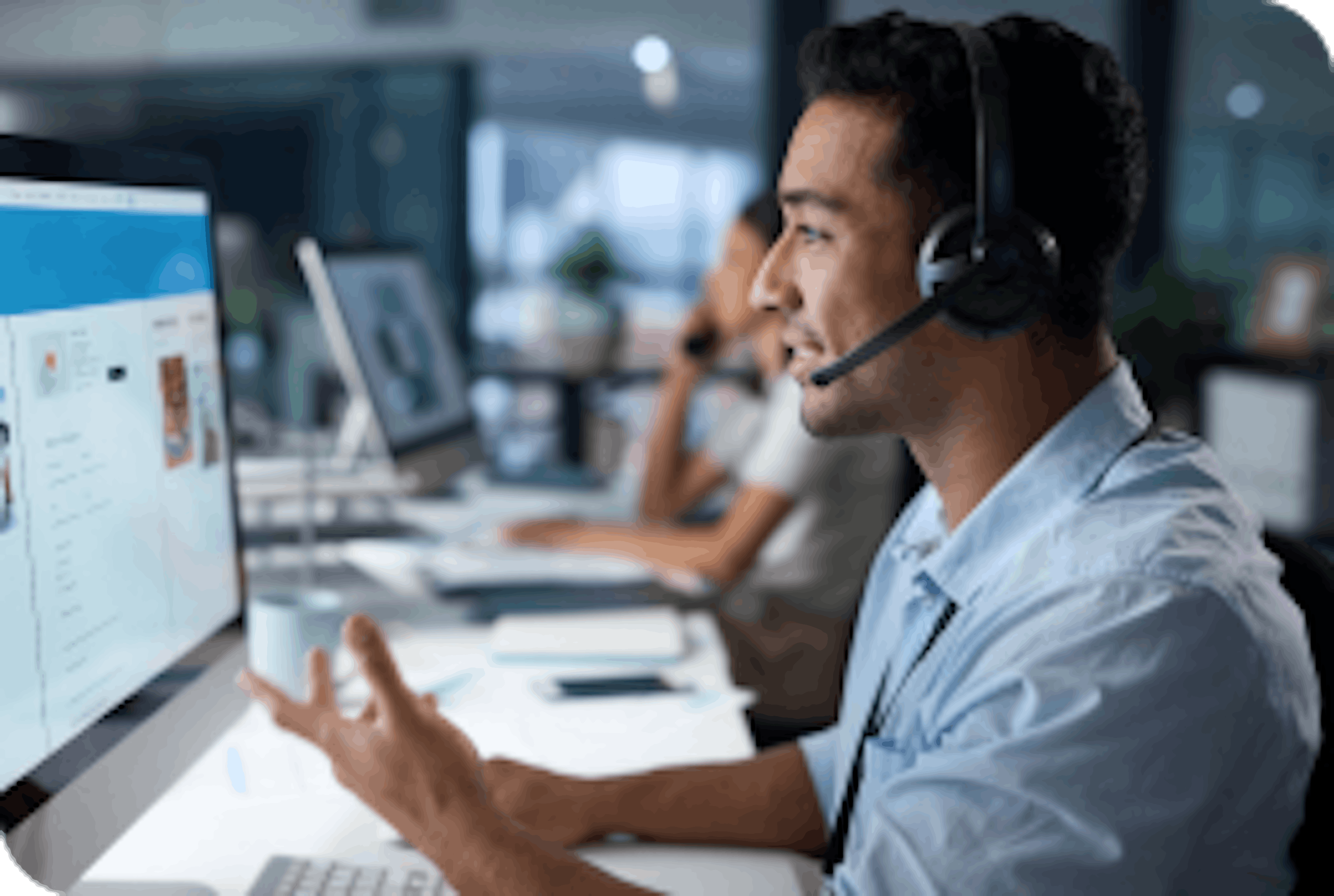 man in control center talking and looking at computer