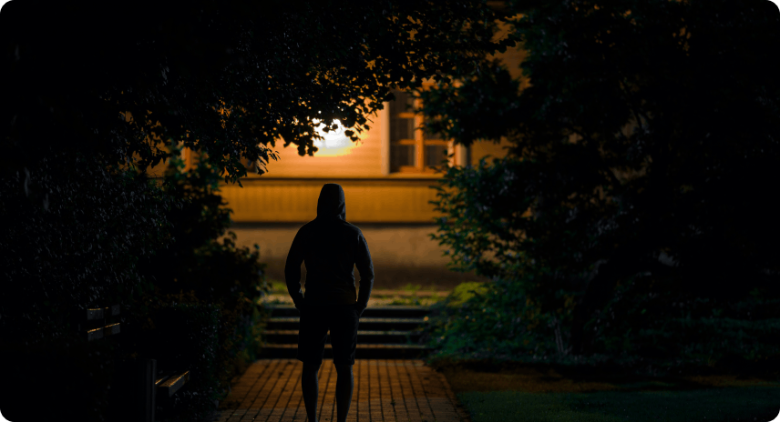 Burglar standing in front of house in the dark of night