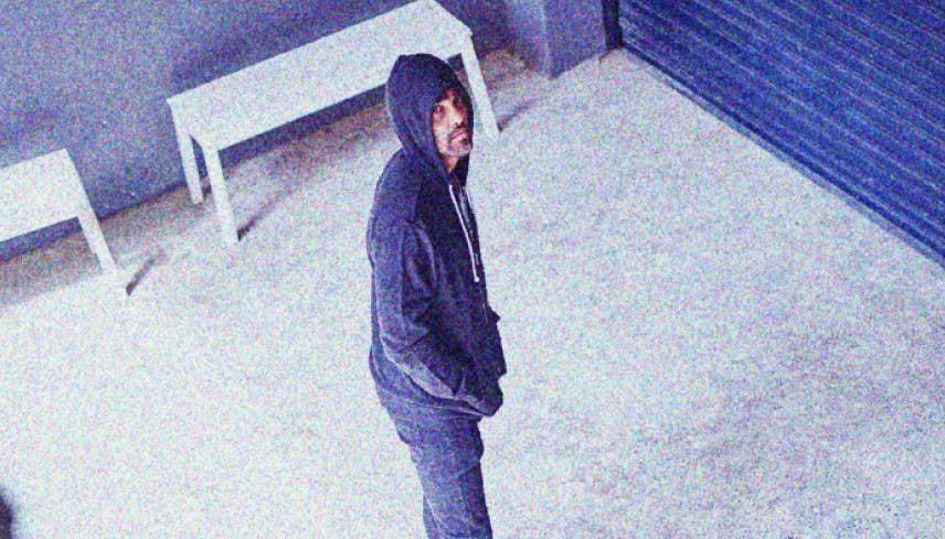 Male person up to no good with a hoodie looking at a surveillance camera