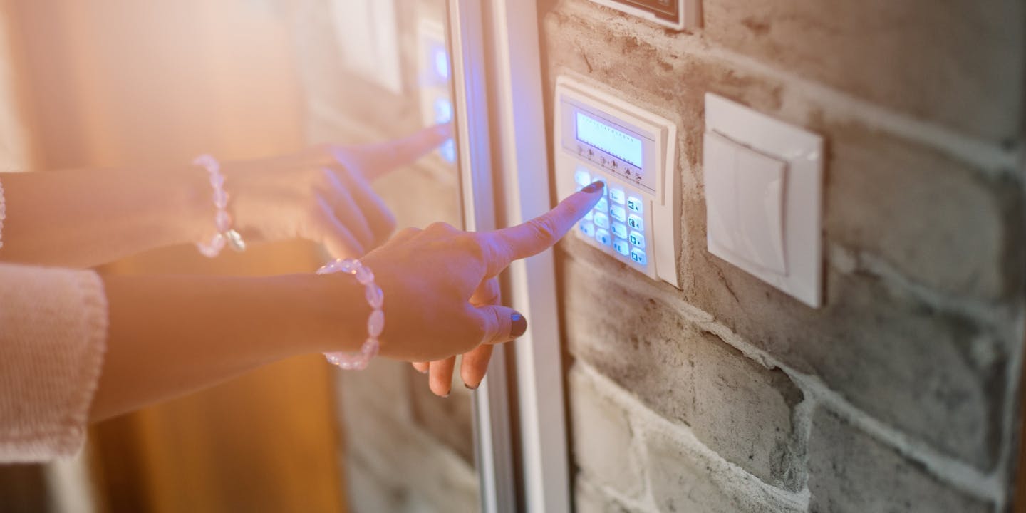 Hand of a young woman operating an access control panel to gain access to a building 