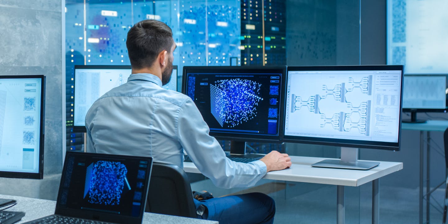 Control room operator working at multiple screens 