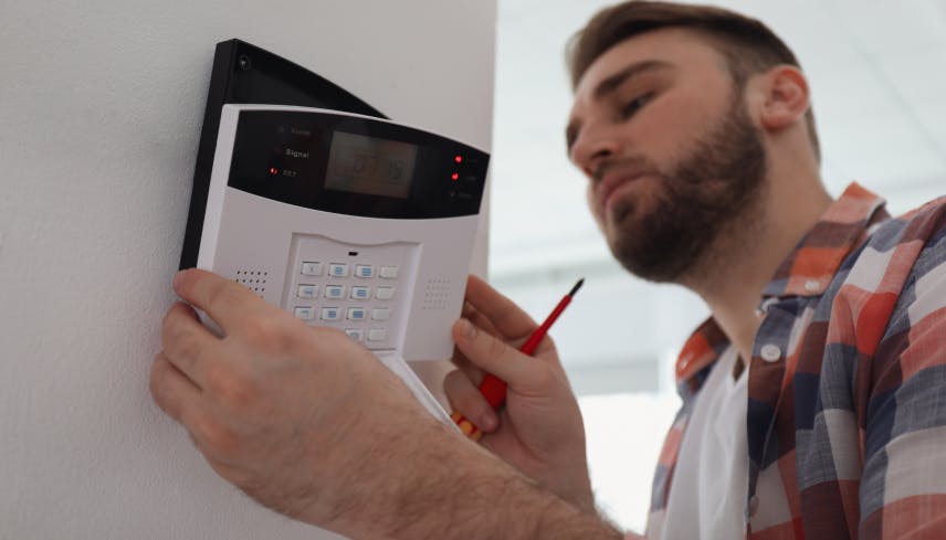 Installer installing an alarm panel