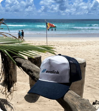 Photo of white and blue evalink base cap on a beach in the Seychelles