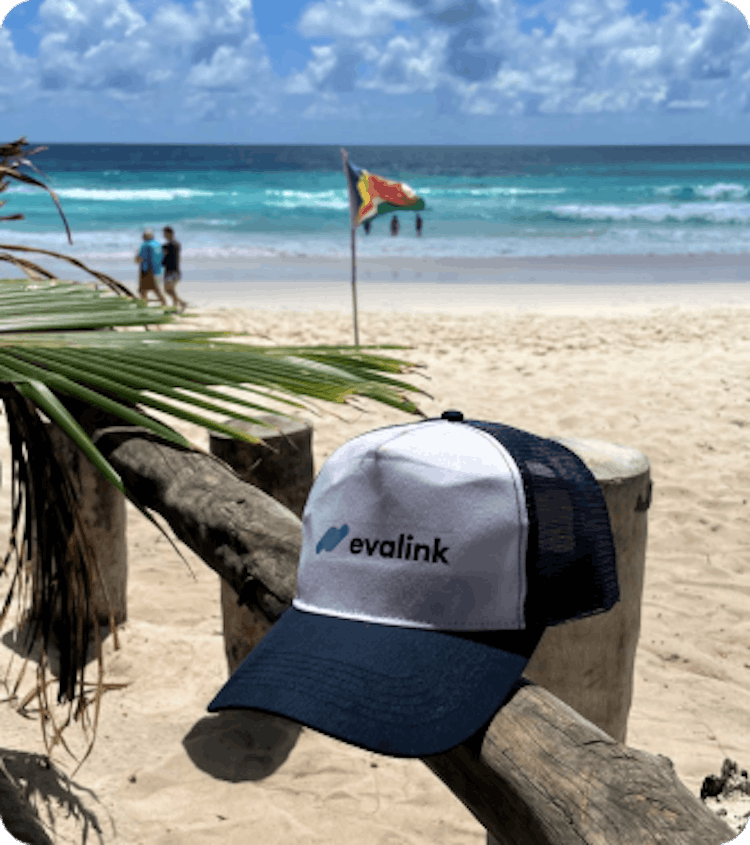 Foto eines weiß-blauen evalink-Basecaps an einem Strand auf den Seychellen