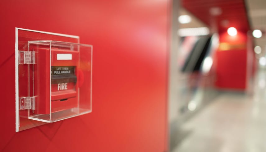 Fire alarm detector mounted on a red wall
