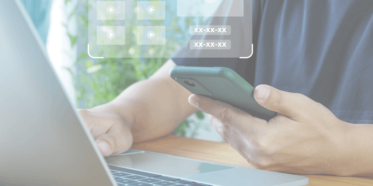 man holding phone and working on laptop to set up camera