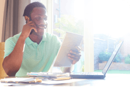 Smiling customer making a good business decision, in his hands the contract, talking on the phone to a Managed Security Service Provider (MSSP)