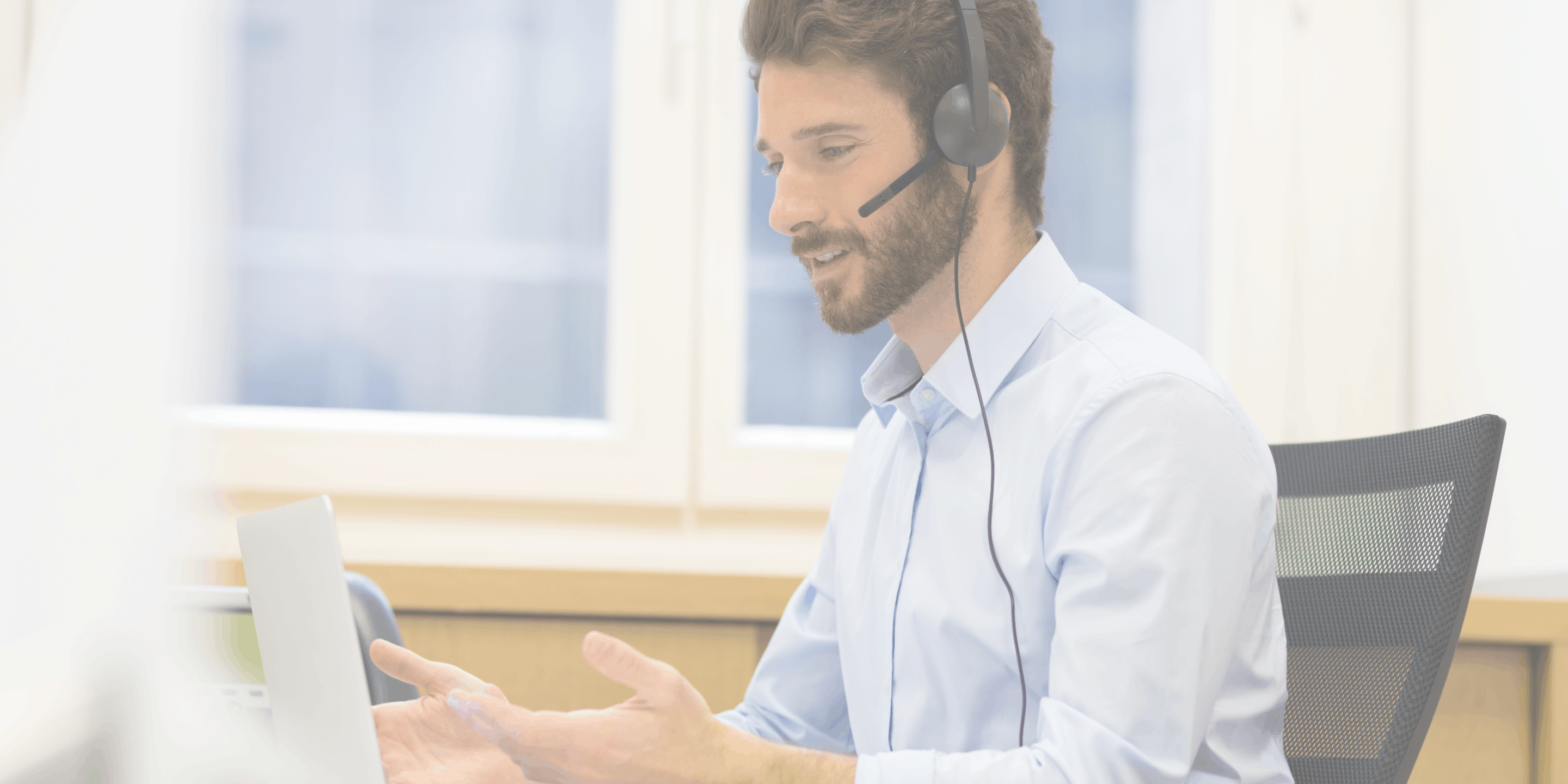 man working on computer and on the phone