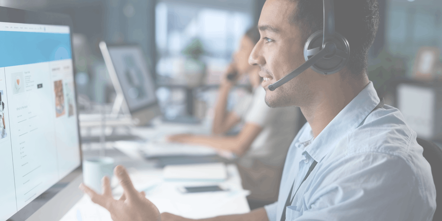 man in control center talking and looking at computer